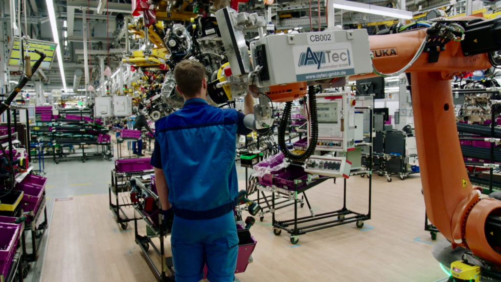 Ein Mitarbeiter arbeitet direkt mit einem Industrieroboter Hand in Hand